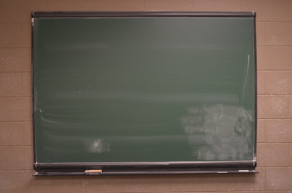A blank green chalkboard in a wooden frame